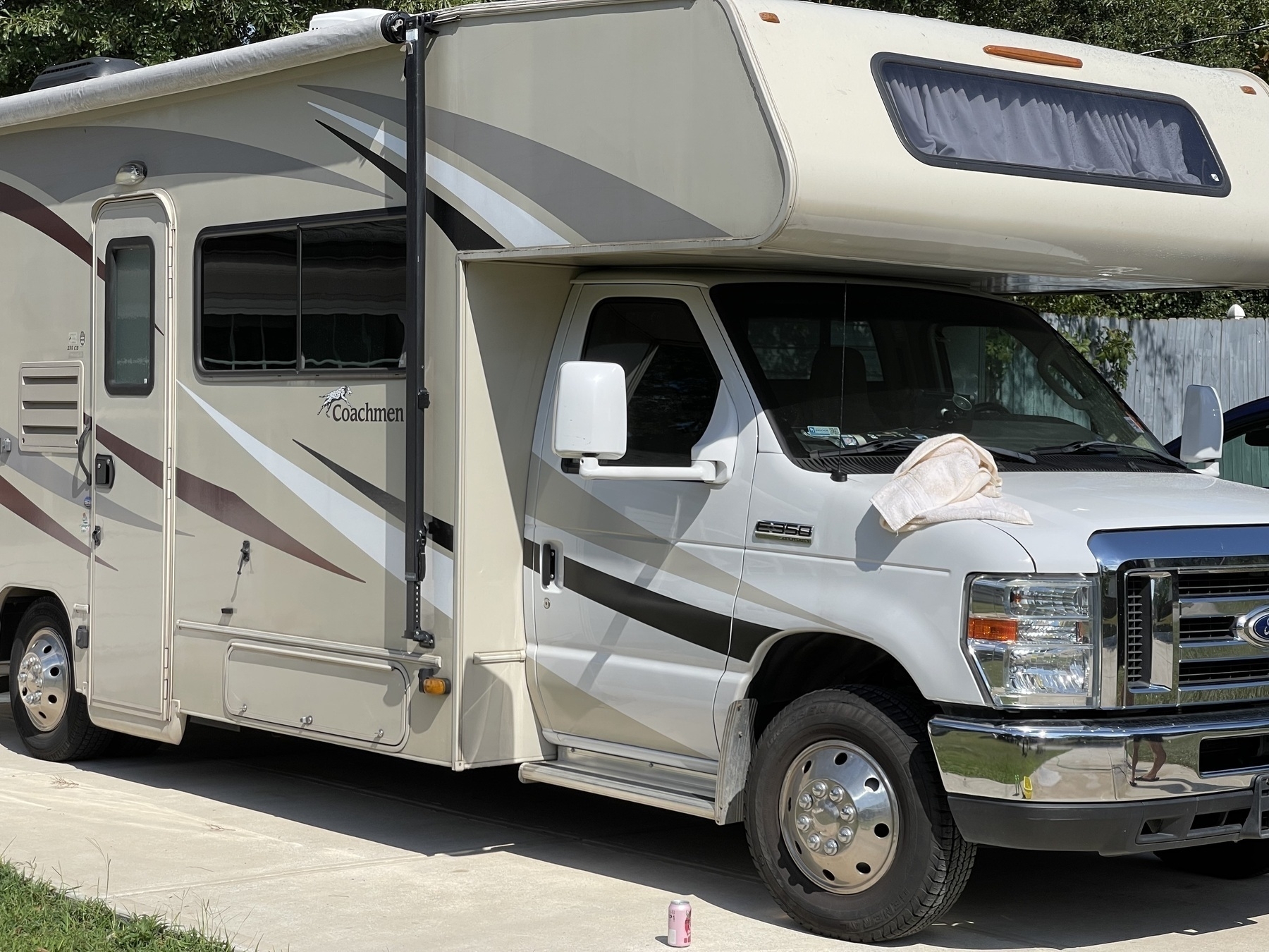 A 2016 class C RV sitting on a Ford Econoline super duty chassis parked in a suburban driveway